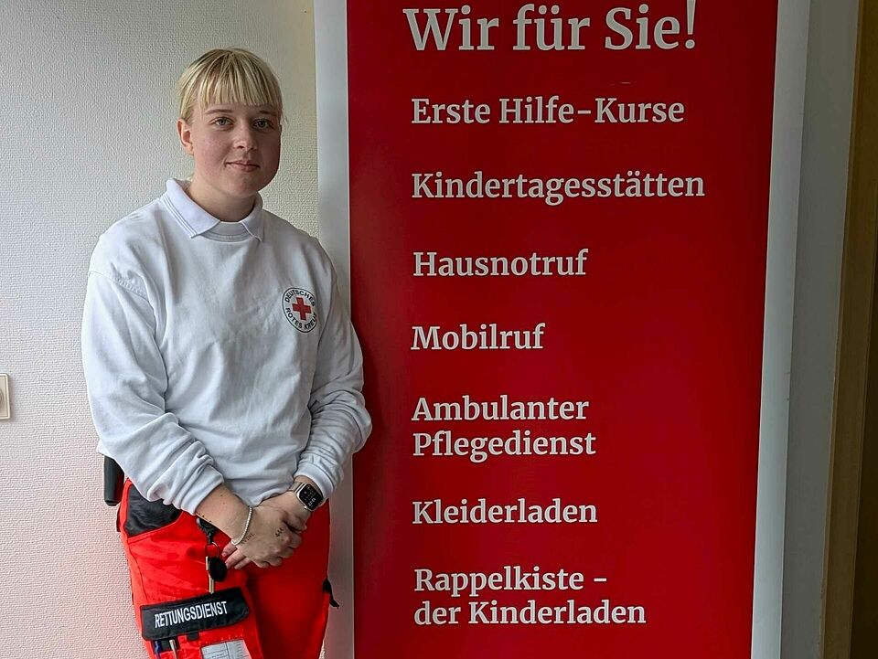 Eine FSJlerin steht neben einem Werbebanner