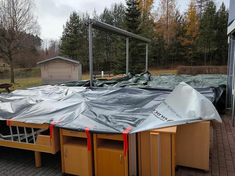 Betten stehen abgedeckt vor einem Haus am Zielort