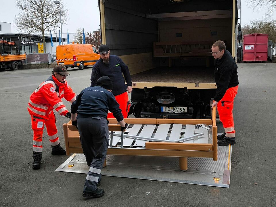 BRK-Helfende entladen ein Bett aus einem LKW