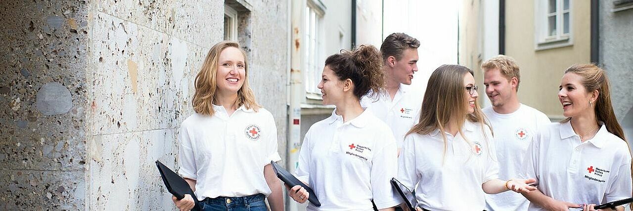 Junge Menschen in Rotkreuz-Kleidung gehen von Haus zu Haus um neue Fördermitglieder zu gewinnen