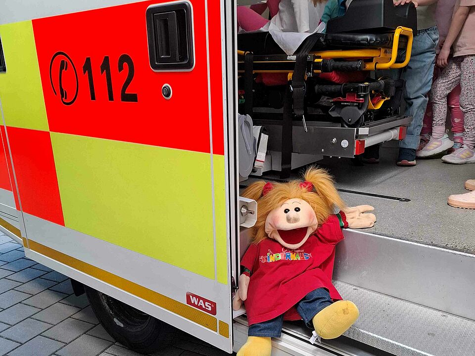 Puppe Solfi sitzt im Rettungswagen