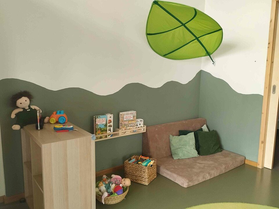 Kissen und Spielsachen stehen gemütlich unter einem Blätterdach