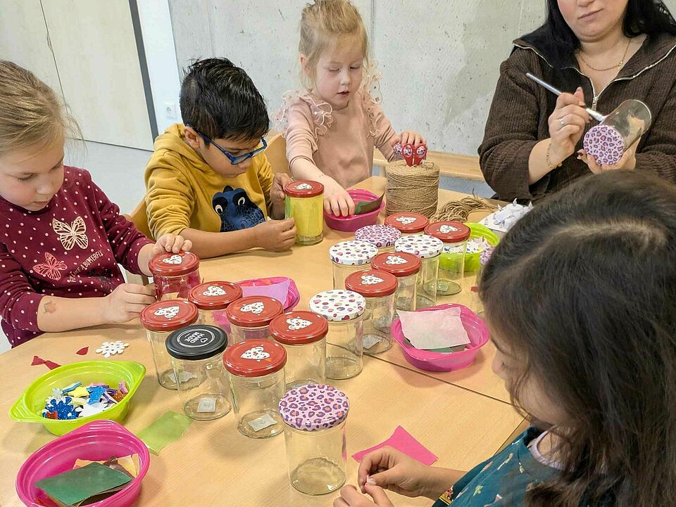 PXL_20251218_084902877.MP Kinder beim Bekleben von Gläsern