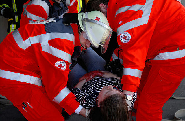 Eine Frau wird von BRK-Sanitätern getragen