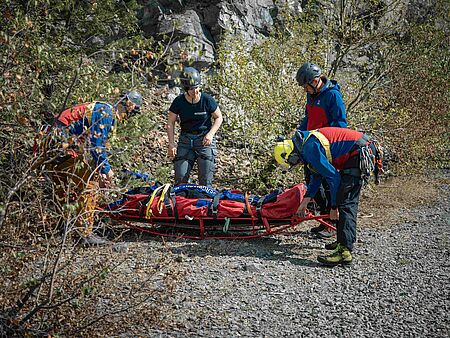 Bergwacht und Notärztin neben einer Rettungstrage