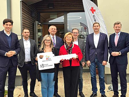 Symbolische Schlüsselübergabe vor dem Gebäude mit den Ehrengästen