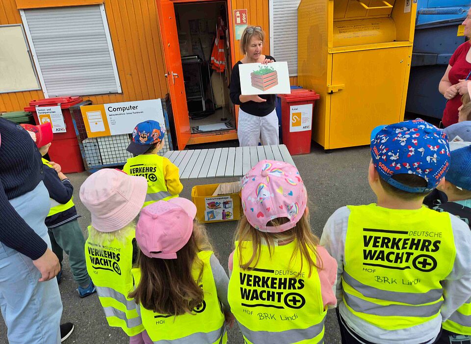 Eine Mitarbeiterin des AZV Hof erklärt Kindern die richtige Müllsortierung