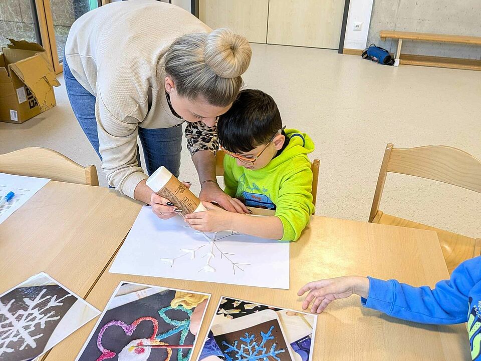 PXL_20251218_084953282.MP Eine Mitarbeiterin von Lifalogistik bastelt mit einem Kind